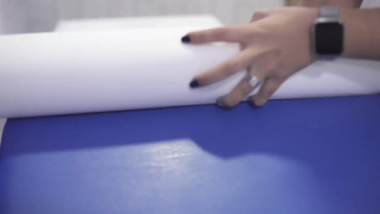 Tracking shot of a worker putting a paper sheet over the massage bed