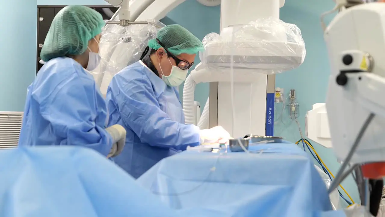 Asian Surgeon Wear PPE Perform Surgey In Operating Room Close Up