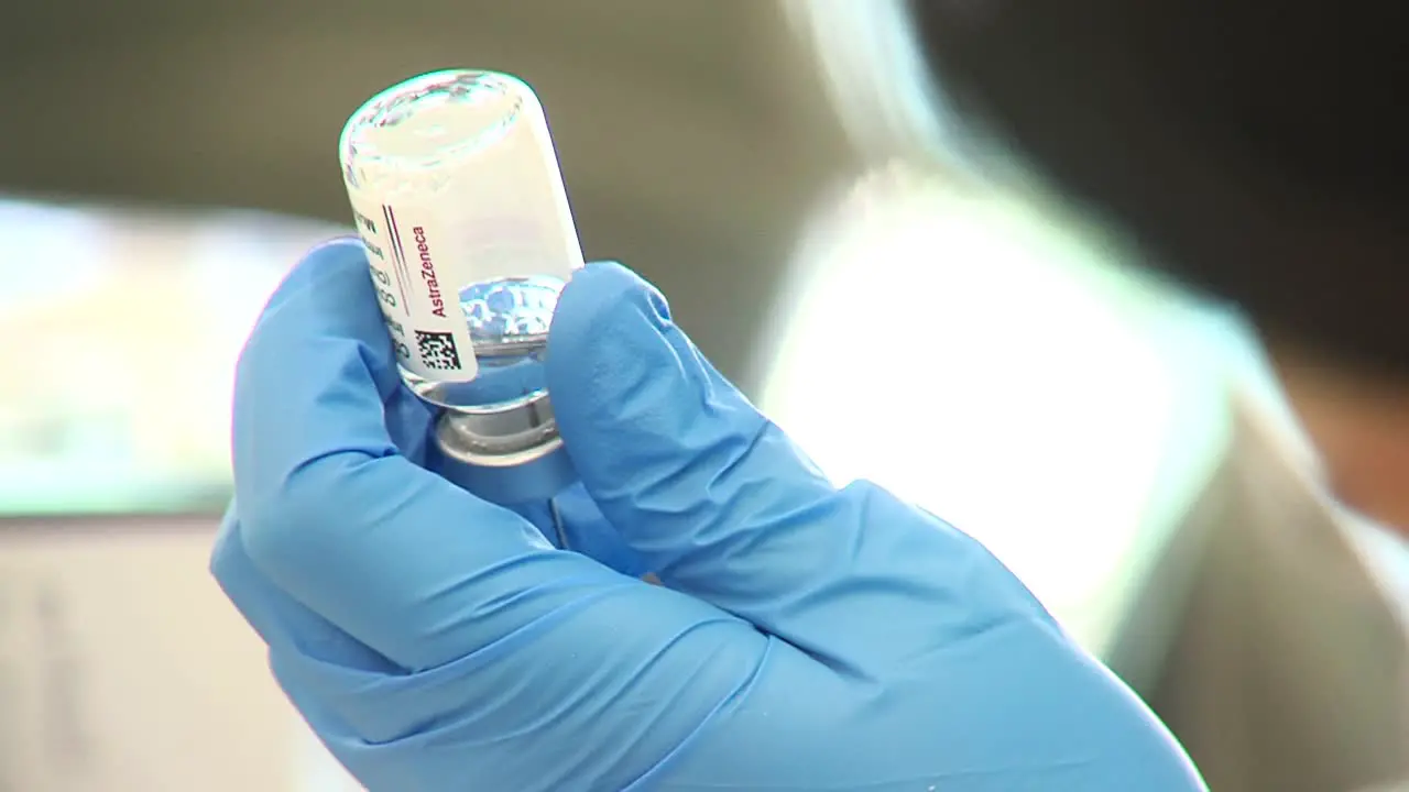 Nurse holds Astra zeneca covid vaccine bottle in hands closeup