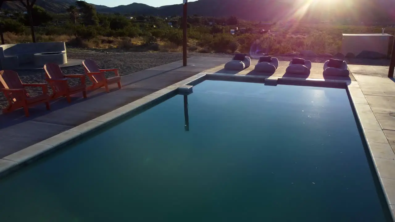 Drone flying over swimming pool at sunset at relaxing holiday resort