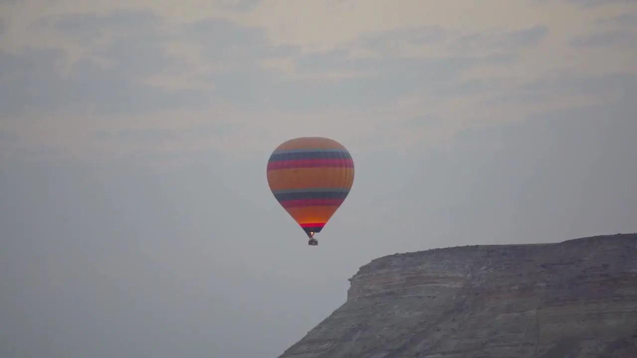 Blue and pink orange balloon flying over the Goreme valley in Cappadocia