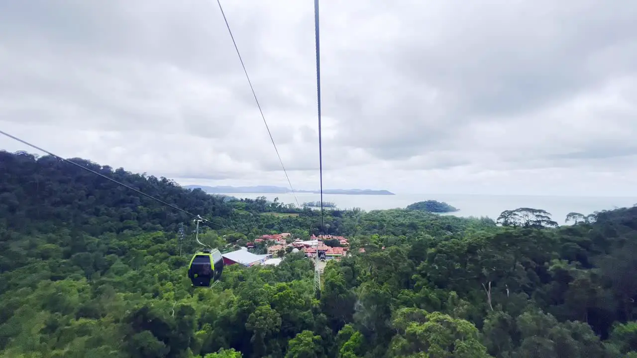 A shot of people going up and down in cable cars over the hills of Langkawi