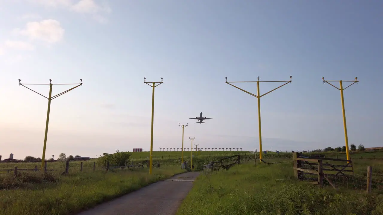 Static Shot of Airplane Departing from Leeds Bradford International Airport in Yorkshire on Beautiful Summer’s Morning with Approach Lighting System in Foreground