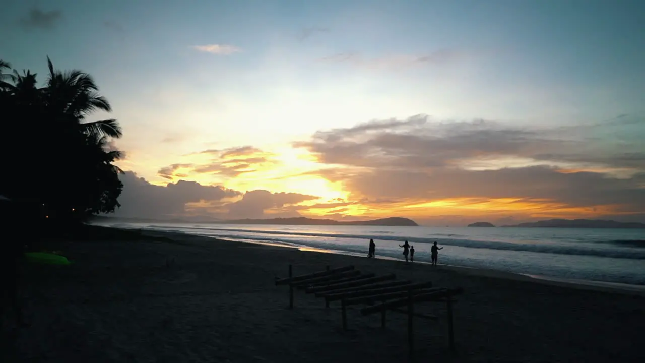 Slowmotion of silhouettes walking down the beach in the Philippines and the sunset is in the background