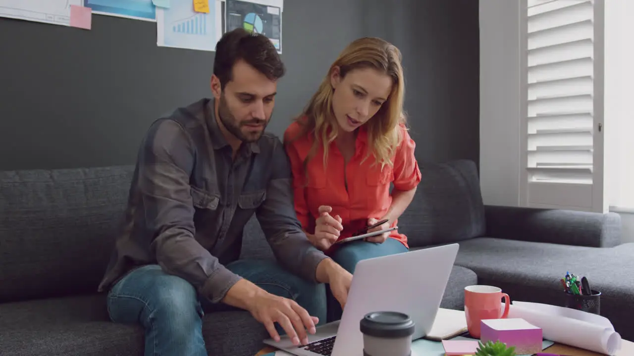 Male and female executives working together on laptop in a modern office 4k