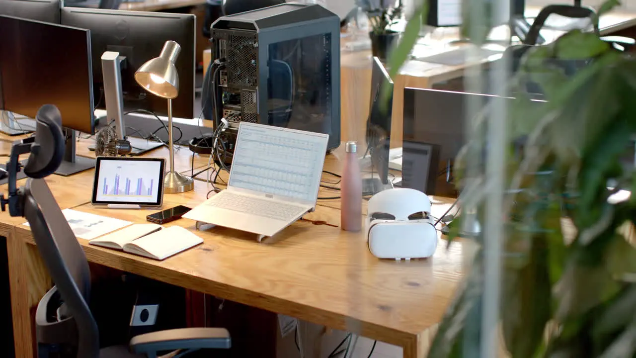 A modern business office desk setup with multiple screens and gadgets