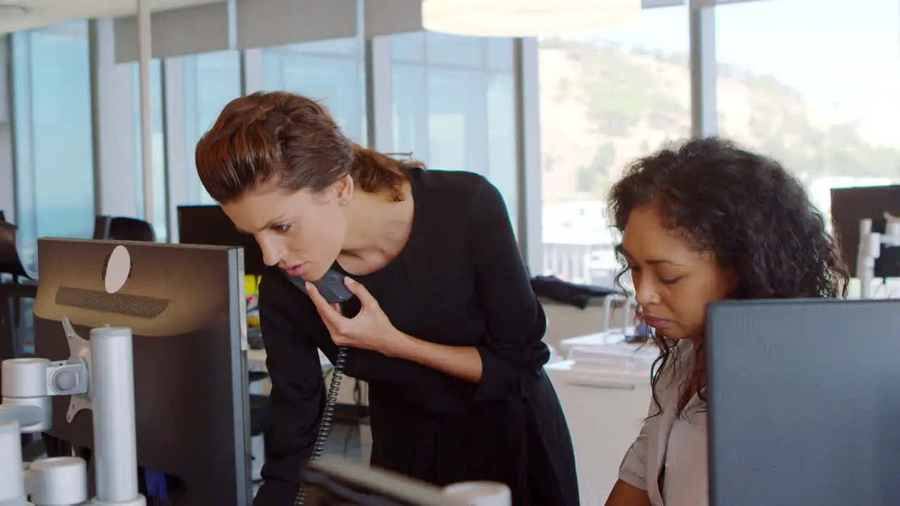 Businesswomen Working At Office Desk On Computer Together