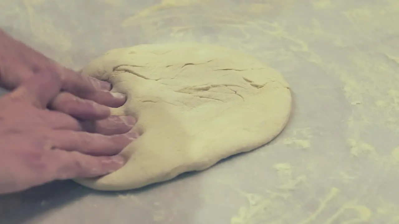 Italian Chef Flipping and Stretching the Pizza Dough with his bare hands on the table