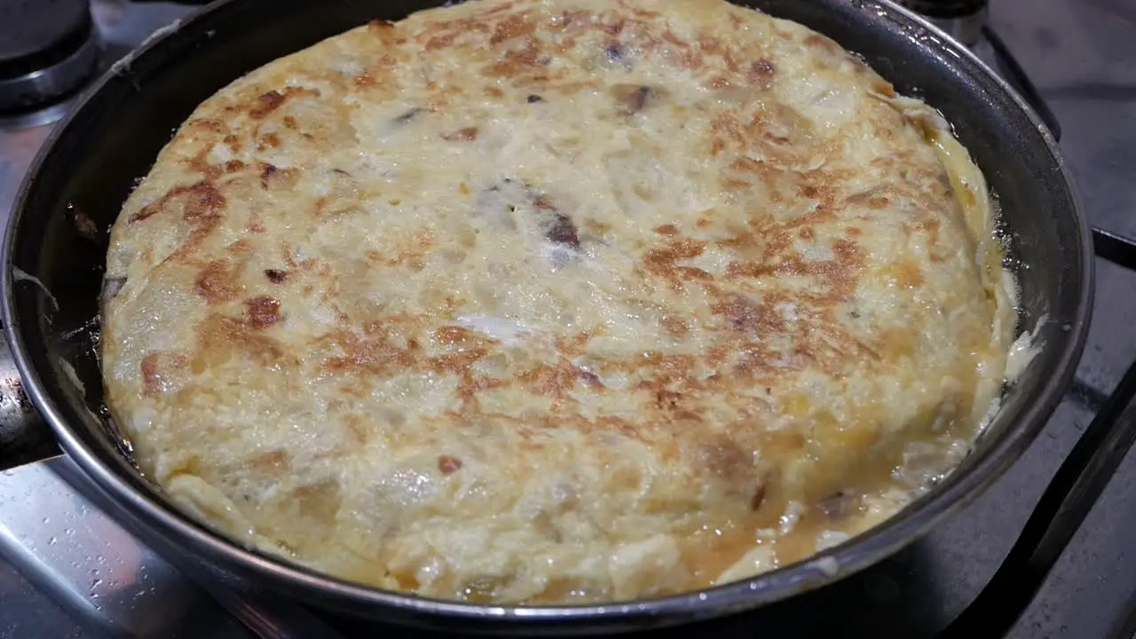 Closeup Spanish omelette tortilla de patatas cooking in pan