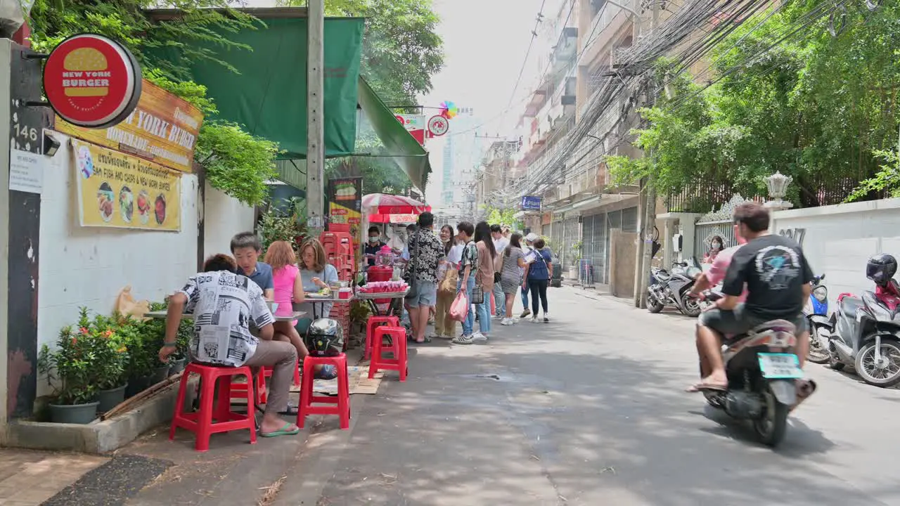 Local diners and tourists lining up for the famous Somtam Thai papaya salad and some Isan Northeastern Thai food in the streets of Bangkok Thailand