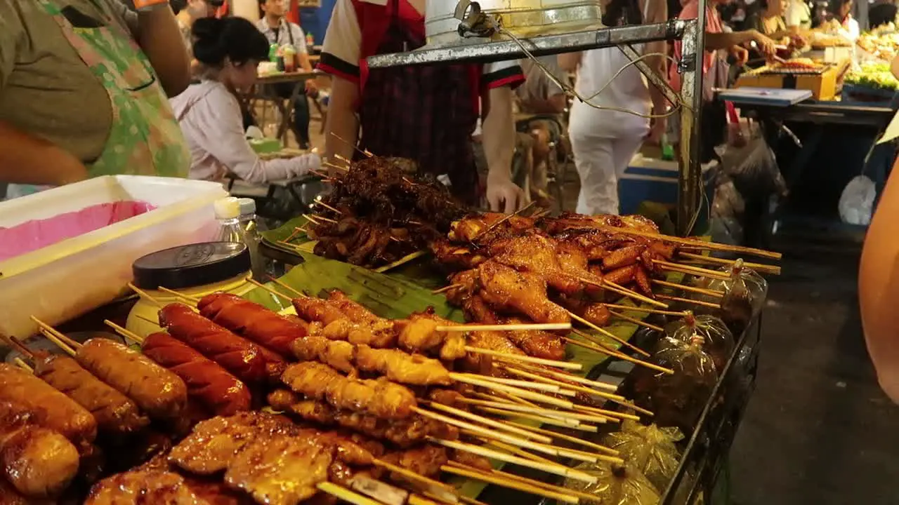 Variety of grilled meat BBQ skewers on street food cart at thai night market