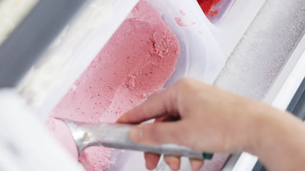 Vertical video of Scooping textured Strawberry Ice cream Slow motion Close-up