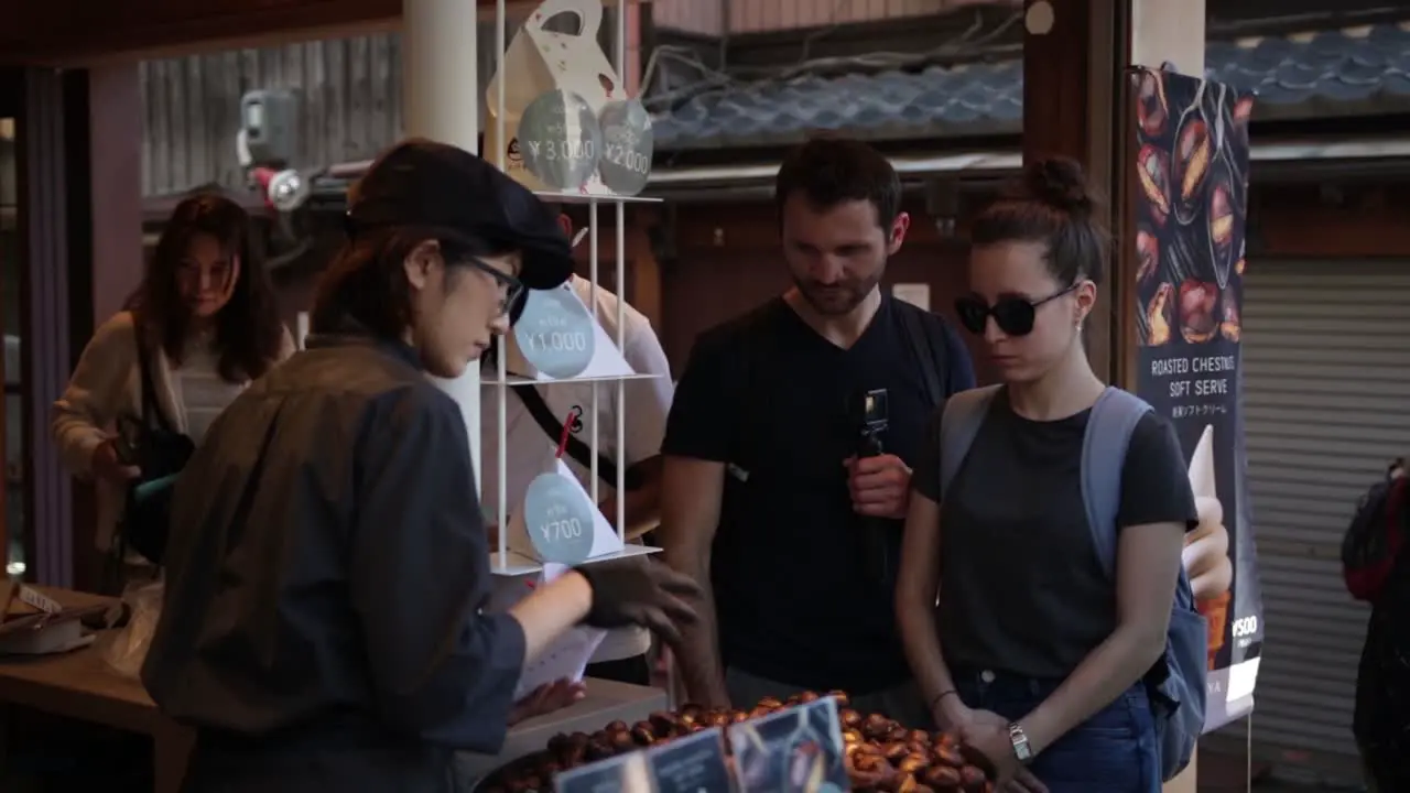 European tourists buying chestnuts in Kyoto Japan