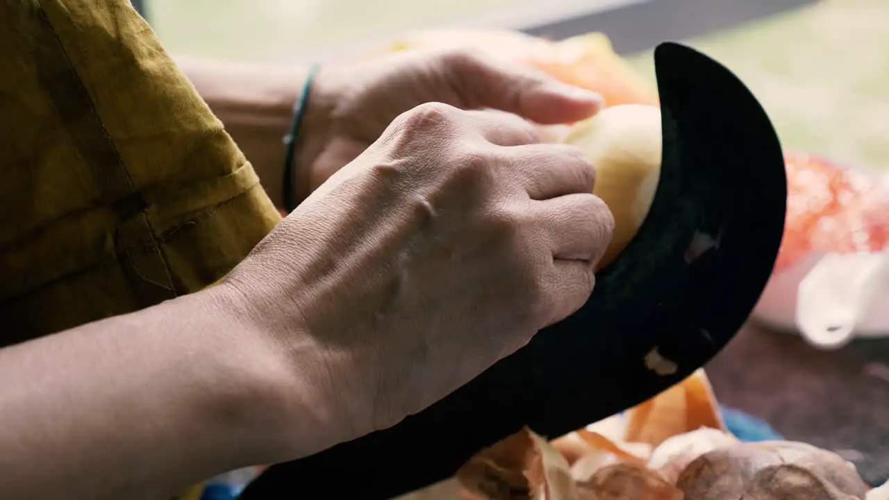 Person using traditional vegetable cutter on onion