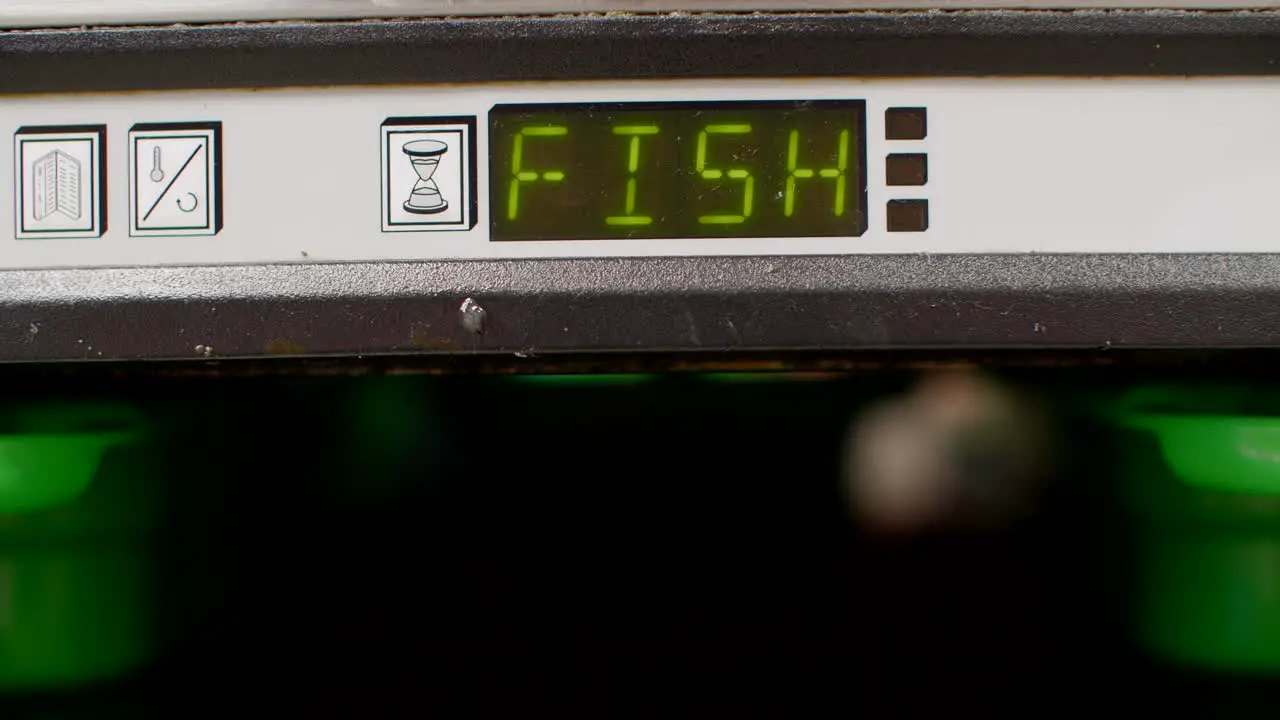 Close-up of fish heat container being pulled out in fast food kitchen