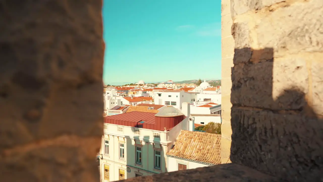 Portugal Loule city through castle wall battlements under blue sky with truck camera movement 4K