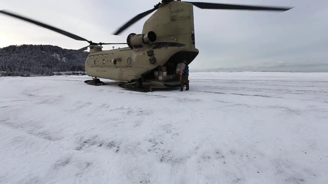 Alaska National Guard Chinook Helicopter Crew Unloads Boxes To Deliver Christmas Gifts To Children In A Remote Village