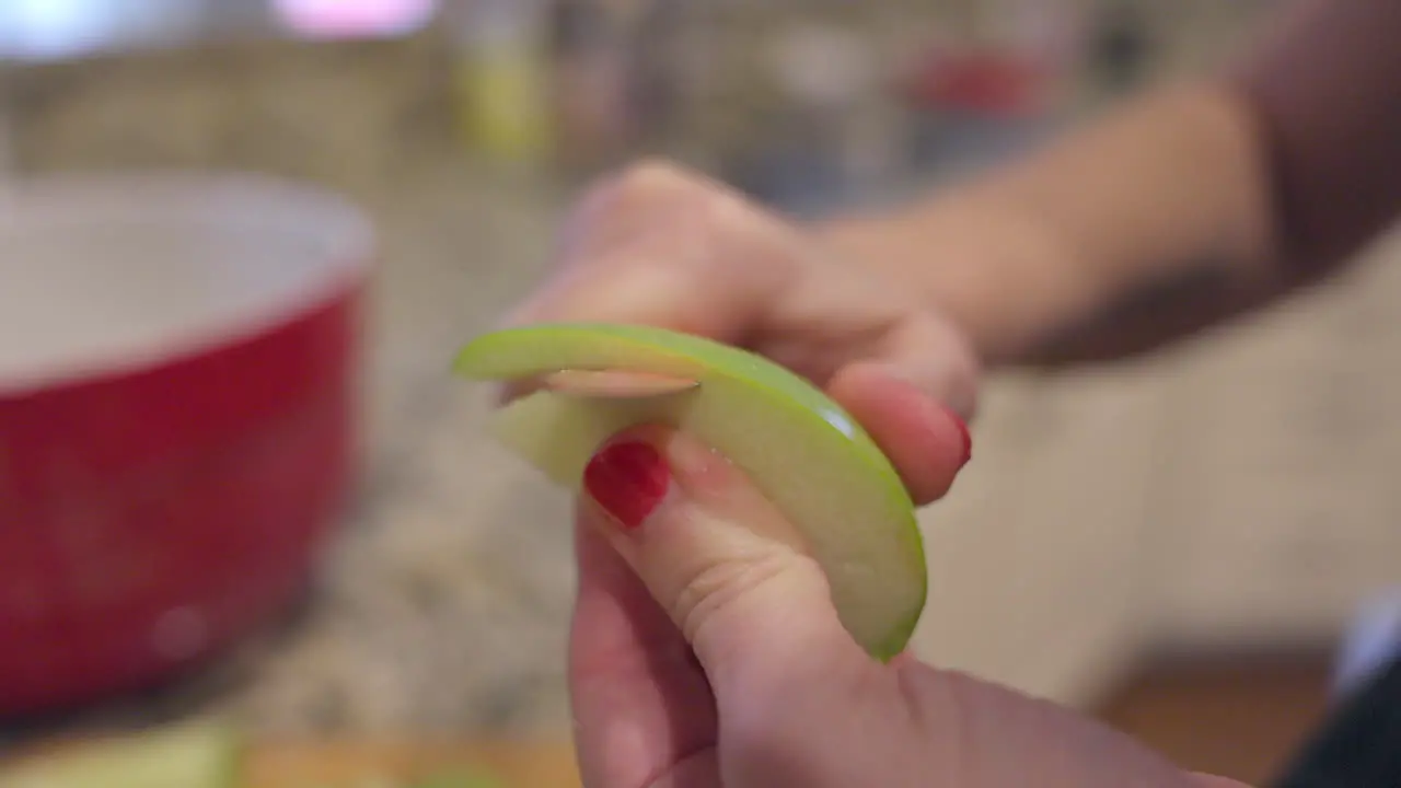 Closeup of an apple slice being peeled in slow motion