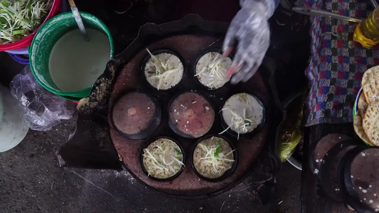 Top view wide shot street cook makes banh xeo traditional Vietnamese squid pancake