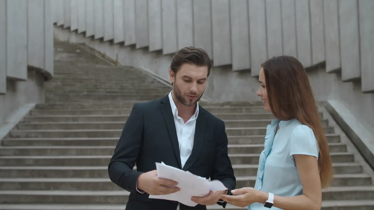 Business couple arguing outdoors Business man throwing documents in air