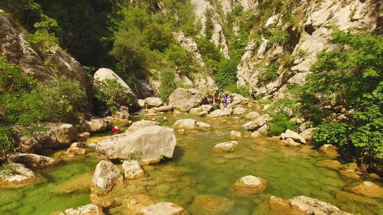 People walking over river on rocks green nature