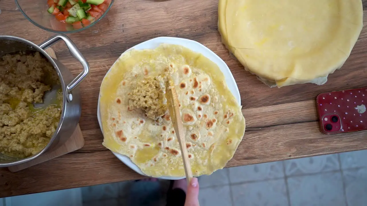 Top Down View of Woman Putting Meat on a Slice of Tortilla