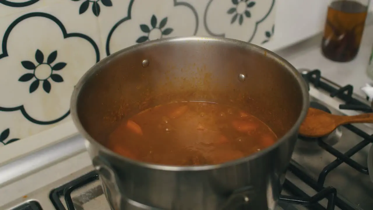 chef adds rice jelly rolls into the hot cooking pot with braised meat and potatoes