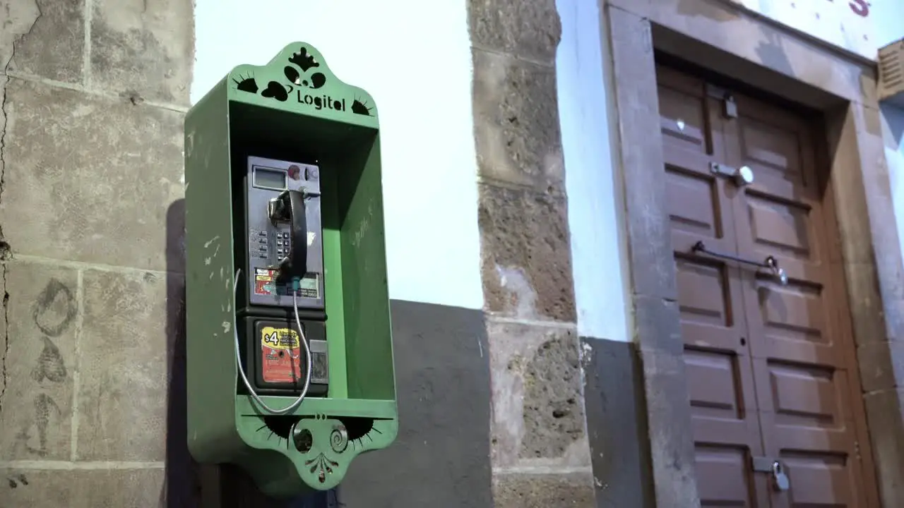 Old green telephone booth in downtown