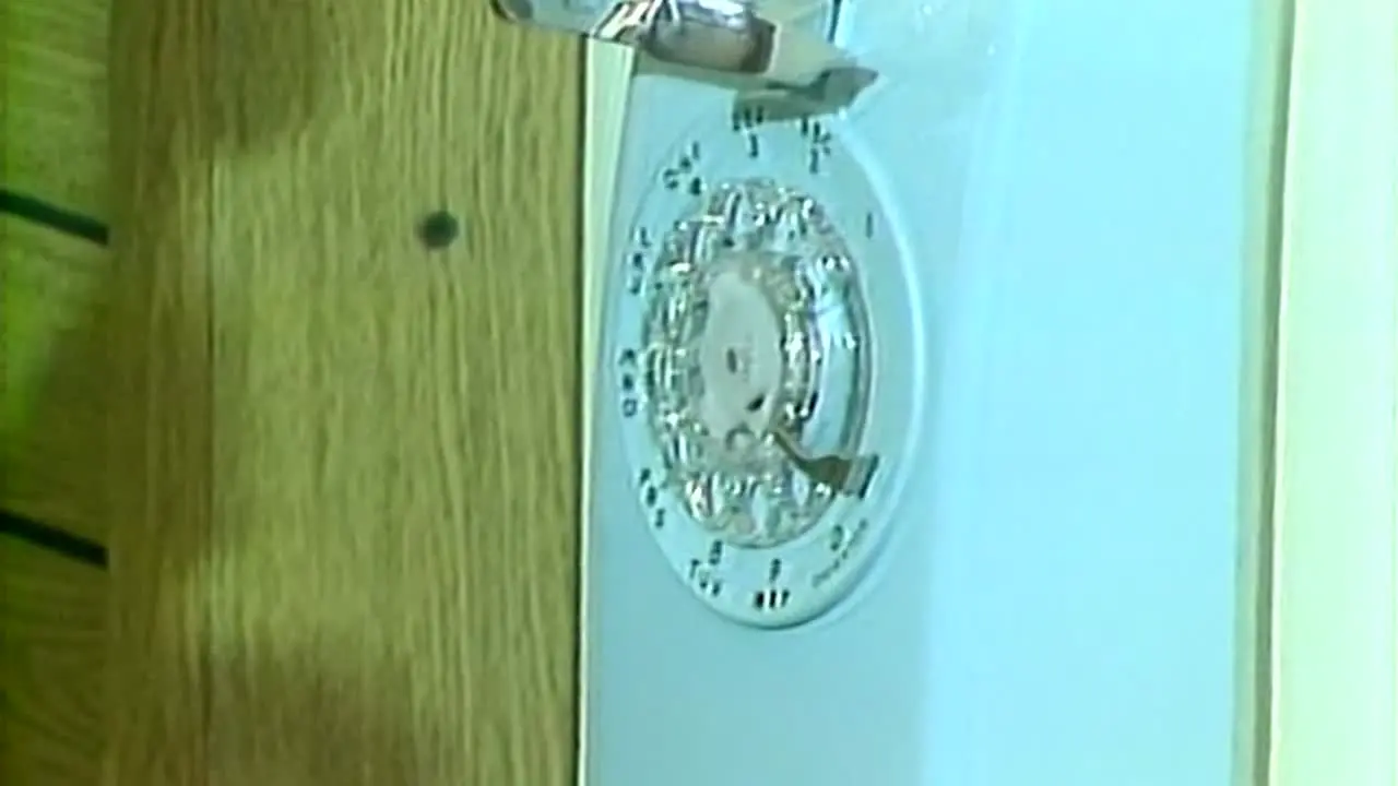 WOMAN'S HANDS PICKING UP AND HANGING UP AN OLD ROTARY PHONE 1983