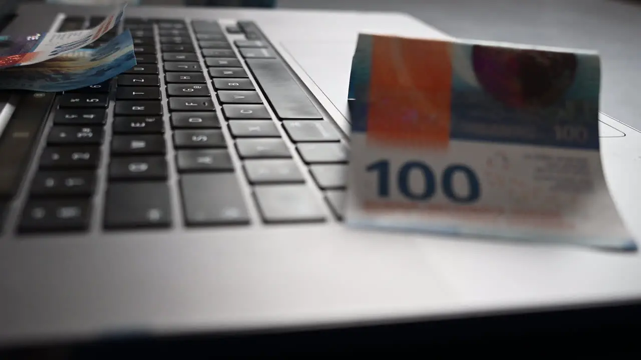 100 buck bank notes on a laptop made from an online business generating cash