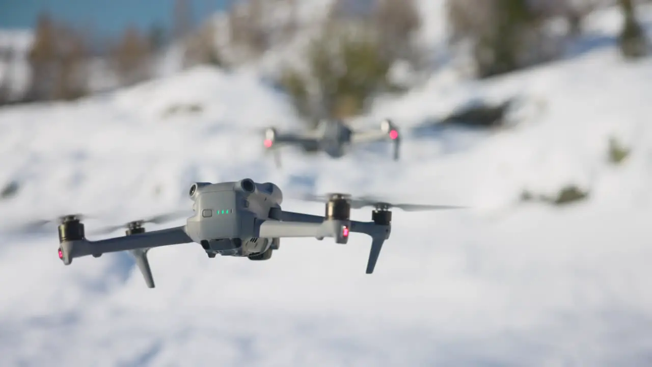 DJI Air 3 Hovering In Front Of Air 2S With Bokeh Snow White Background