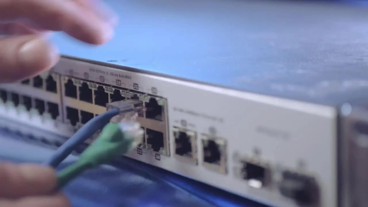 Network engineer securing Ethernet cables into switch