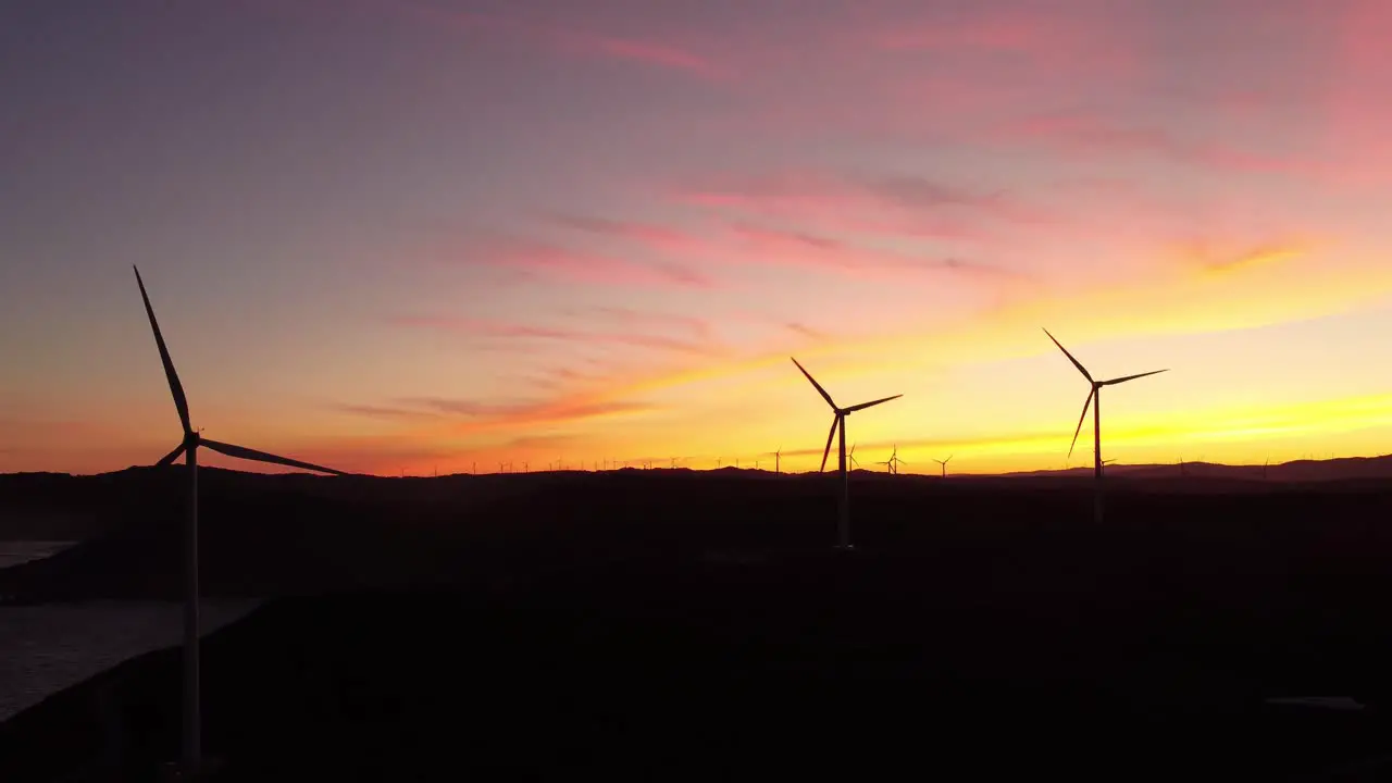 Wind turbine farm silhouette during colourful sky at sunset