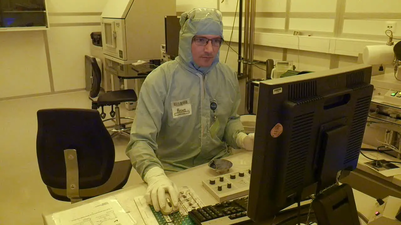 A scientist working on a computer handling a big electrone microscope