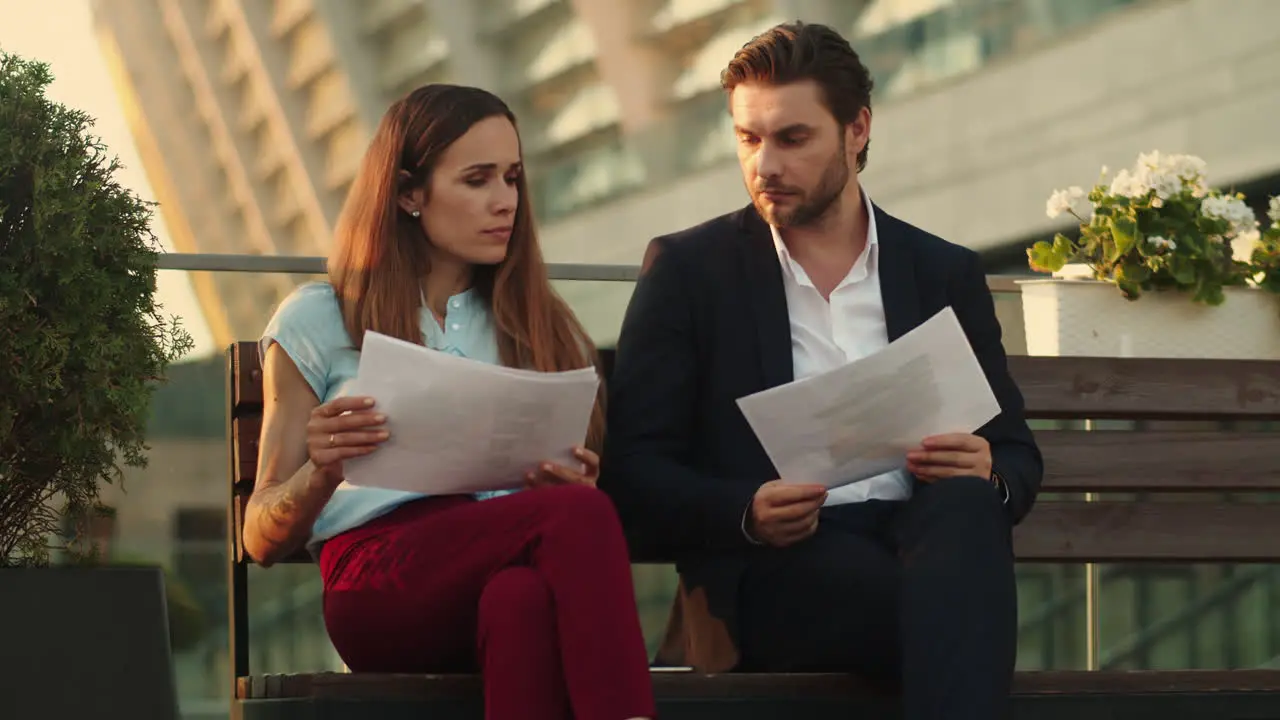 Business people looking at documents on street Coworkers analyzing graphics