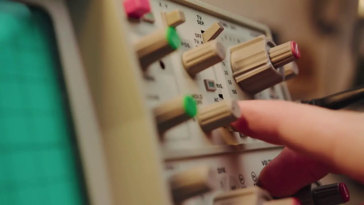 Closeup plugging in a cable operating a knob and manipulating a highly sophisticated electronic vintage device