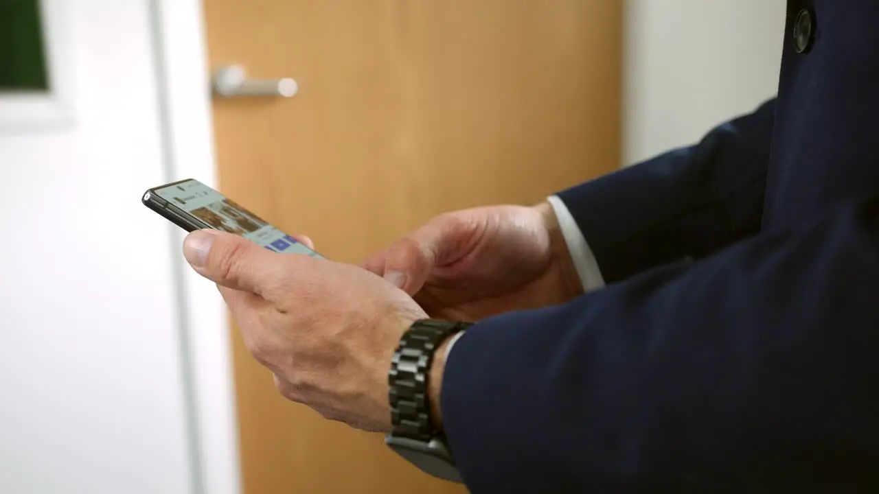 A businessman in a suit using a smartphone