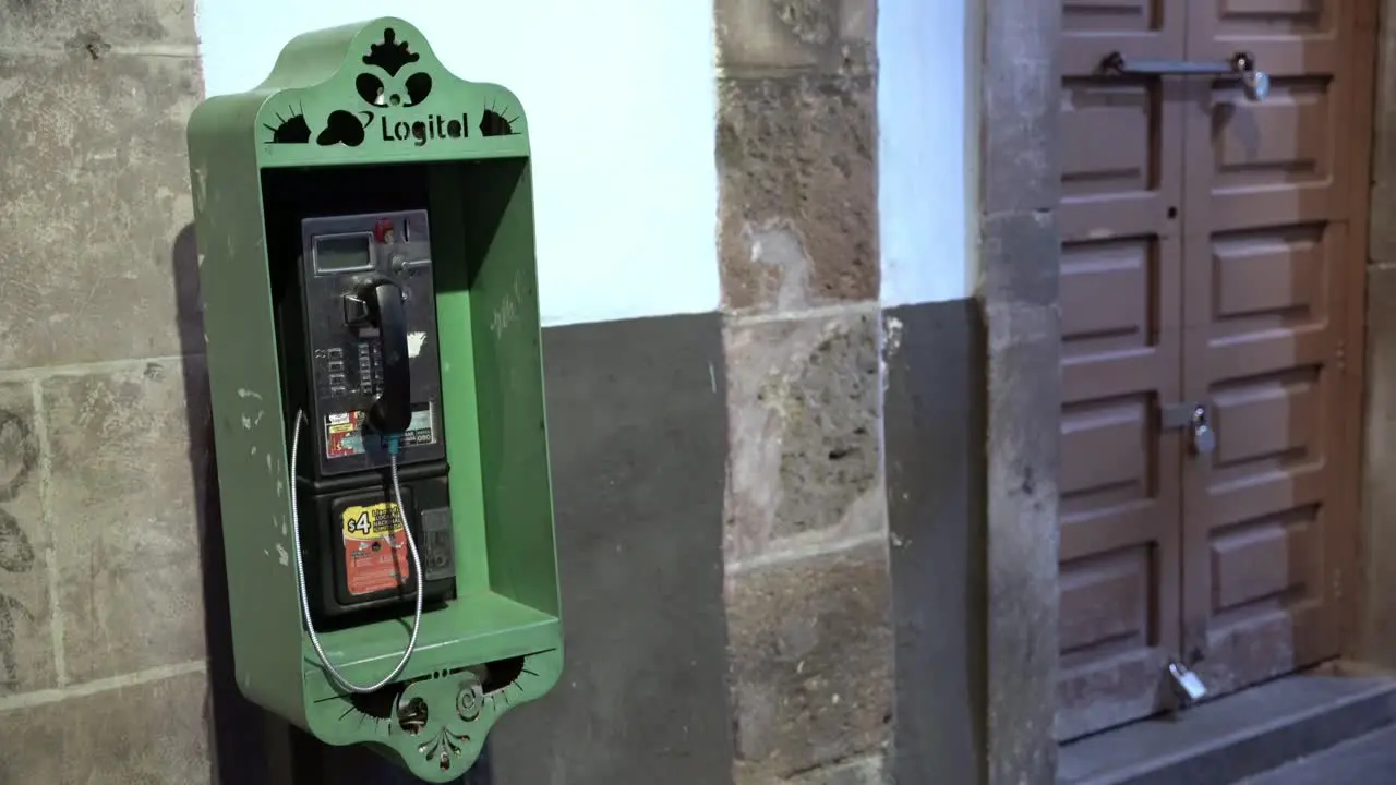 Old green telephone booth in the city