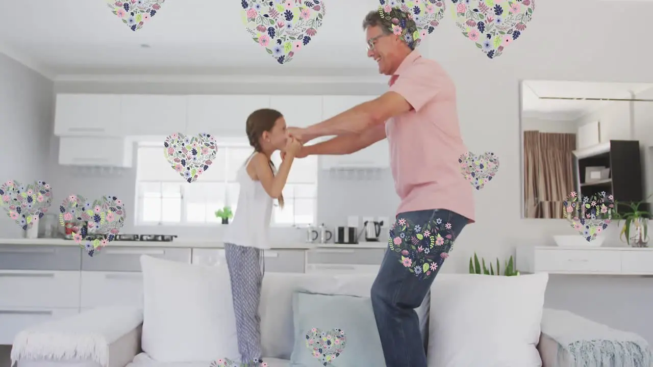 Animation of happy caucasian grandfather and granddaughter jumping on sofa