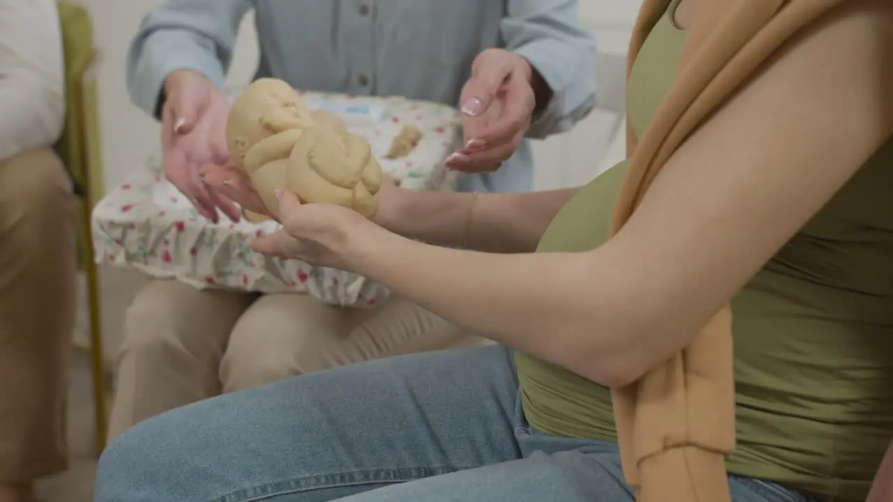 Pregnant woman holding toy baby