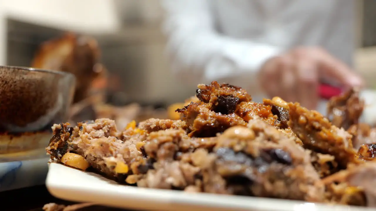 Turkey stuffing with gravy with family dad cutting in the backgroud