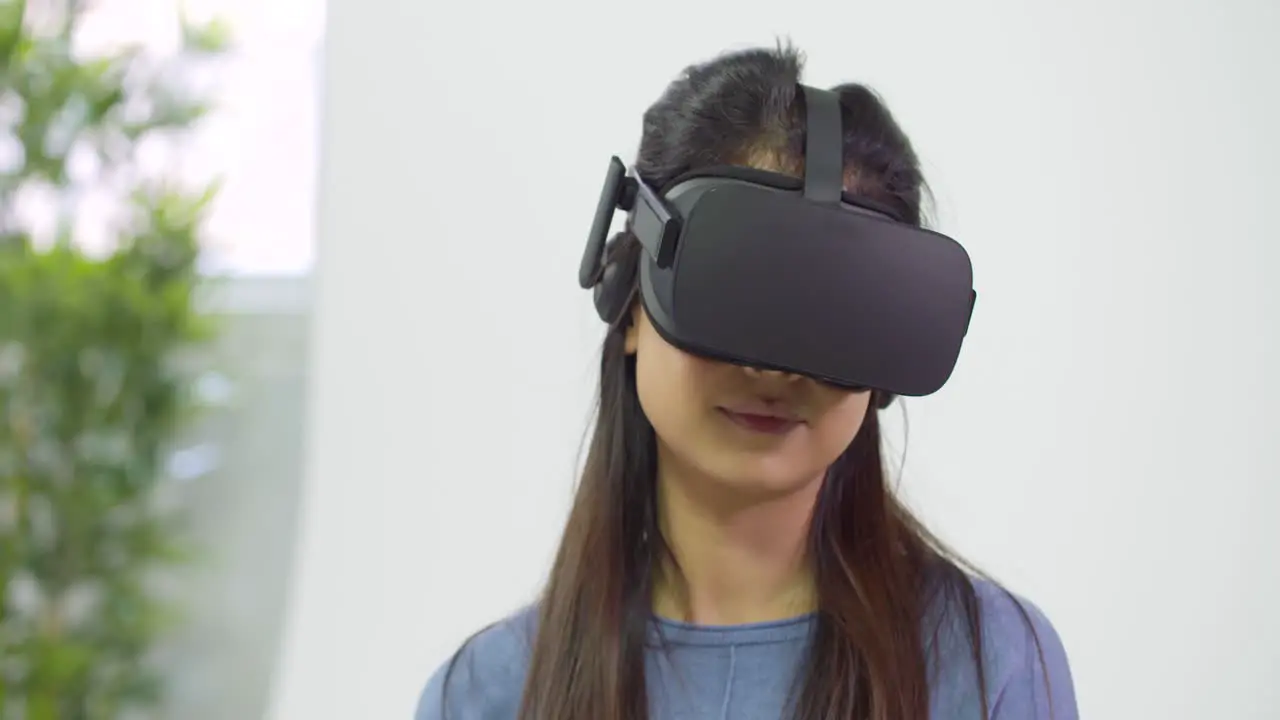 Young Lady Gesturing and Looking Around in VR Headset