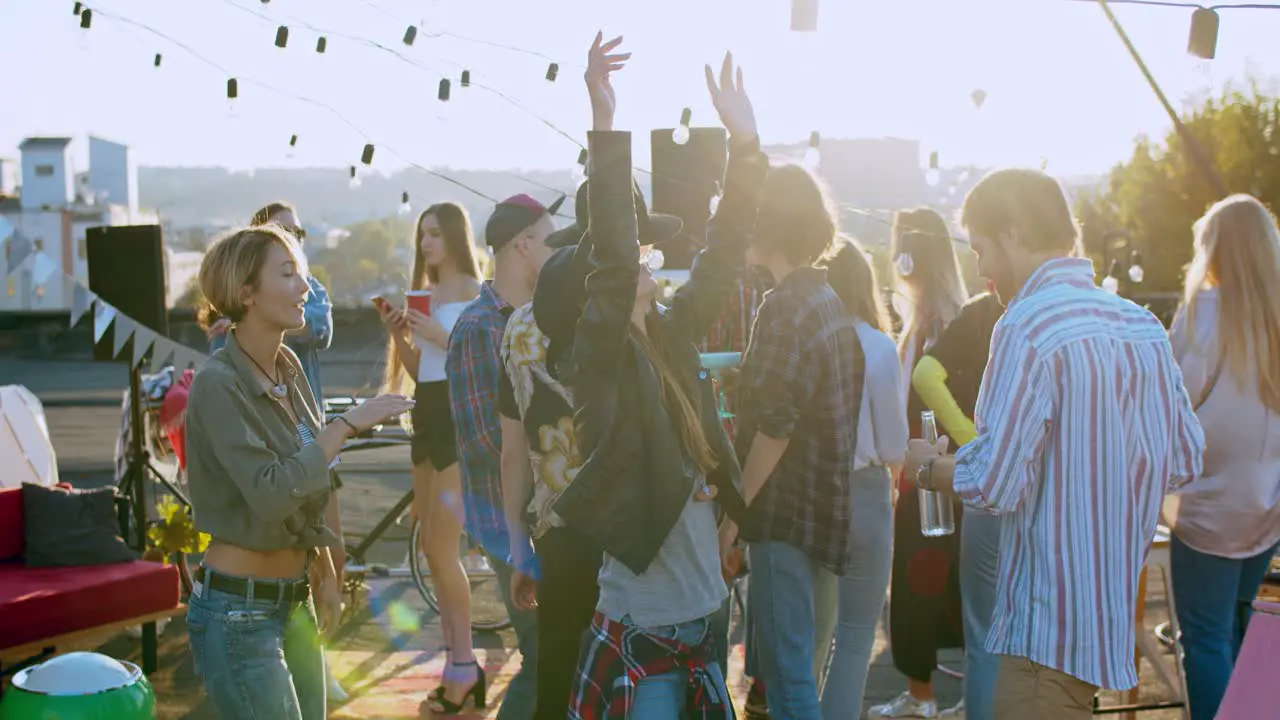 Beautiful Stylish Young Girl In A Hat And Dark Sunglasses Dancing Joyfully At The Rooftop Party Then Handsome Guy Joining Her