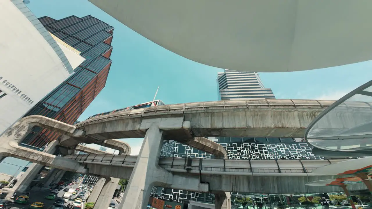 View of the busy and bustling life in Bangkok filled with cars and a passing train