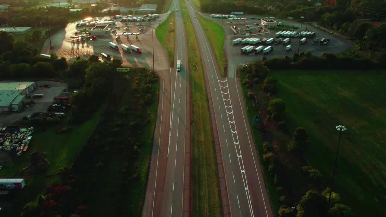 Magic aerial of semi truck on interstate between service plaza area