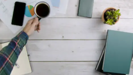 Man Taking Cup of Coffee Away Before Placing It Back On Table