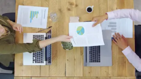 Top View of Woman Giving Man Paperwork in Rustic Office