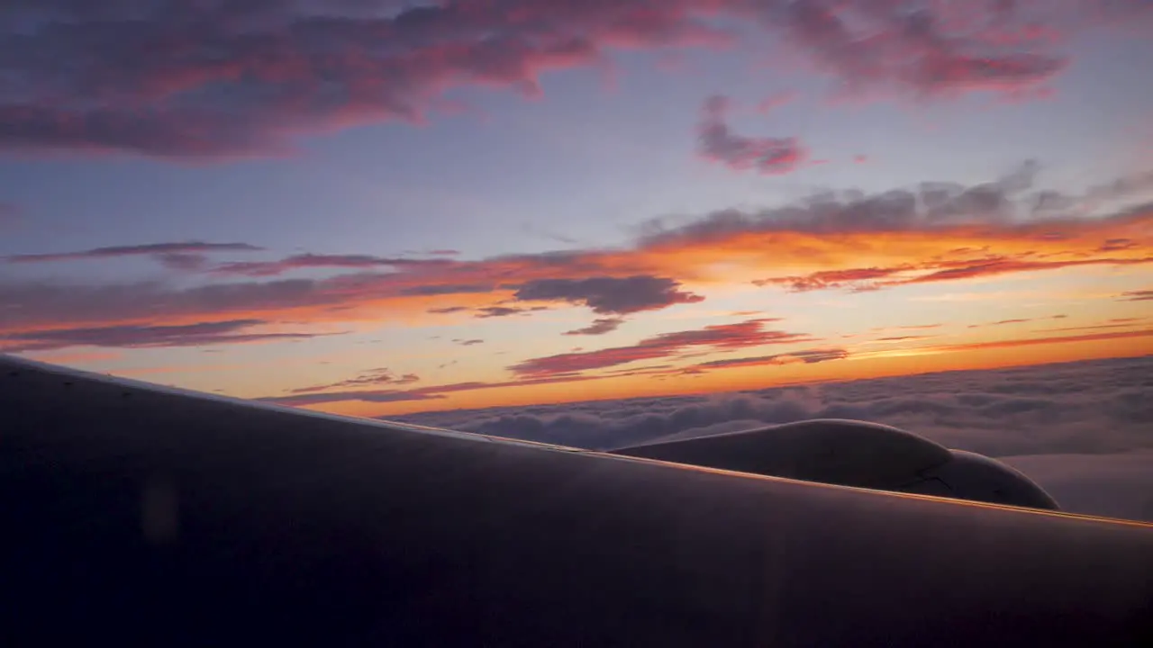 Multiple planes taxiing towards the runway illuminated by the orange hue of the setting sun