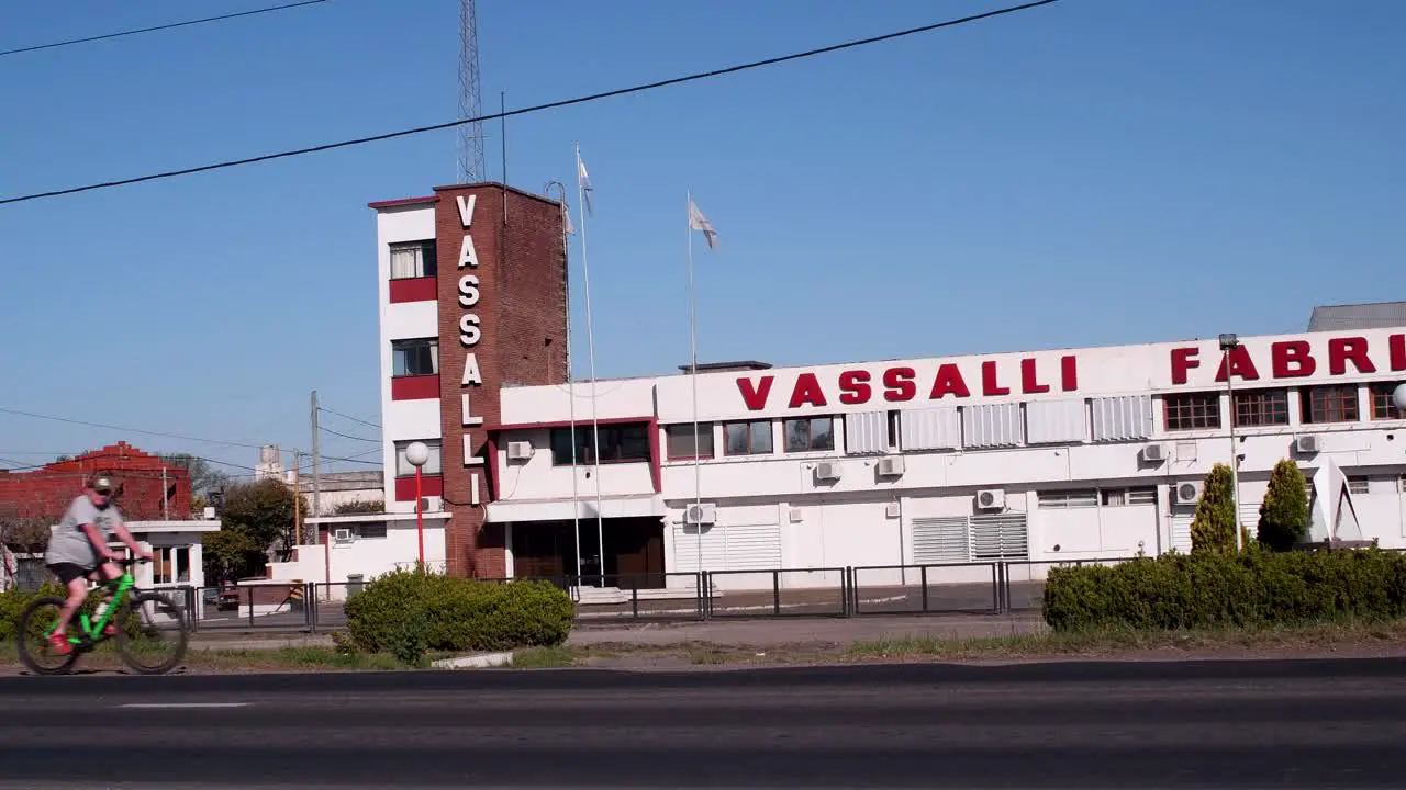 A truck moves right to left through National Route 33 in front of harvester manufacturer Vassalli's plant as a bike goes the opposite way