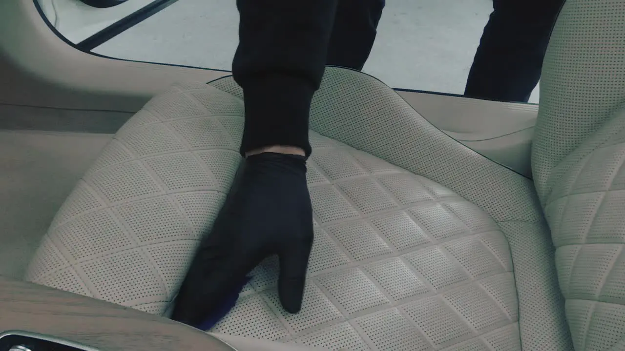 Cleaning a white leather chair in car slow motion